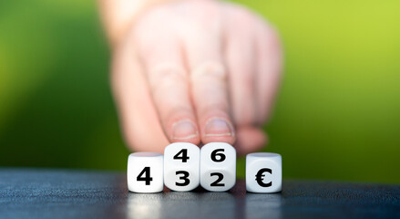 Symbol für die Erhöhung des Hartz 4 Regelsatzes. Hand dreht Würfel und ändert den Ausdruck 432...