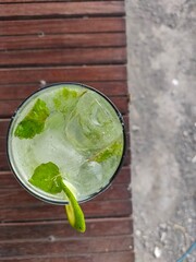 Cold drink in a glass against a wooden table backdrop