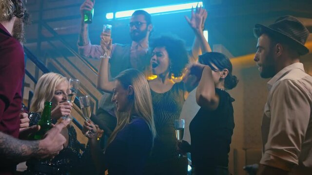 The days we'll remember forever. Group of young friends at the disco, drinking alcohol and dancing
