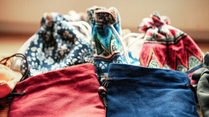 Multicolored soft textile bags with tie-ups, macro photography with blurred background. 