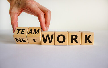 Male hand flips wooden cubes and changes the inscription 'network' to 'teamwork' or vice versa. Beautiful white background, copy space. Business concept.