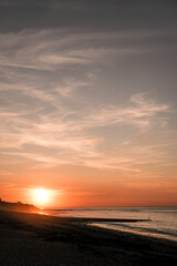 puesta de sol naranja sobre playa francesa, en las isla de re.