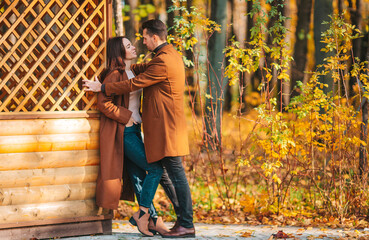 Happy family walking in autumn park on sunny fall day