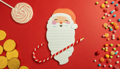 Santa Claus' christmas letter on paper with candy around it. Space to write the gifts.