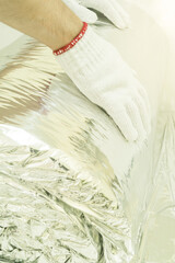 Man hand working insulation aluminum foil encapsulate.