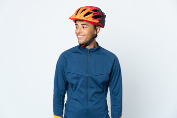 Young cyclist Brazilian man isolated on white background looking to the side and smiling