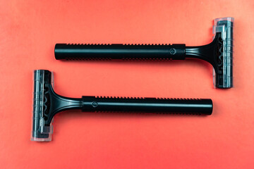 Black shaving razors on red background
