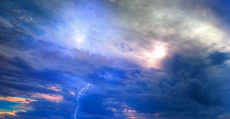 Lightning strikes between stormy clouds.