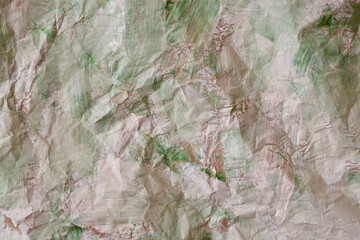 Paper crumpled and colored with chaotic strokes of paint as a background.