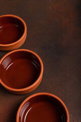 Obraz na płótnie Canvas Three clay bowls on a dark background