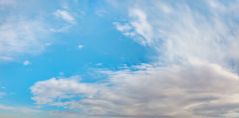 Blue sky and white clouds background - Pillowy clouds cover a blue sky in the background
