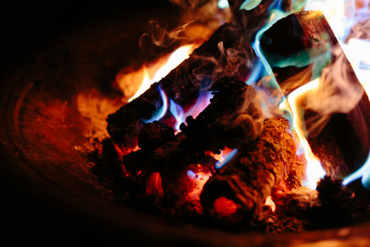 Coloured flames in firepit from specially coated pine cones