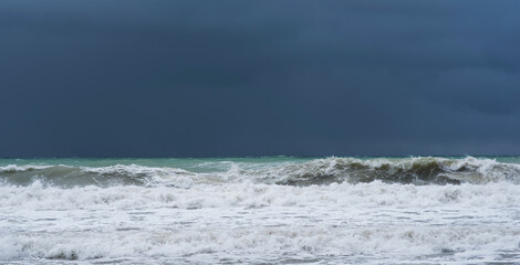 Autumn sea landscape. Rough sea with waves during autumn stormy weather. Dark heavy clouds in the sky. Dark and dramatic storm clouds background.