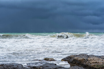 Autumn sea landscape. Rough sea with waves during autumn stormy weather. Dark heavy clouds in the sky. Dark and dramatic storm clouds background.