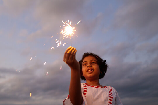 Little girl with sparkler just after sunset
