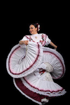 Bailarina mujer latina vistiendo traje de Aguascalientes México, fondo negro, con vestido blanco con cintas color vino, moviendo su falda y sonriendo
