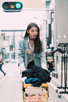 Stylish Woman Pushing Shopping Cart On Street