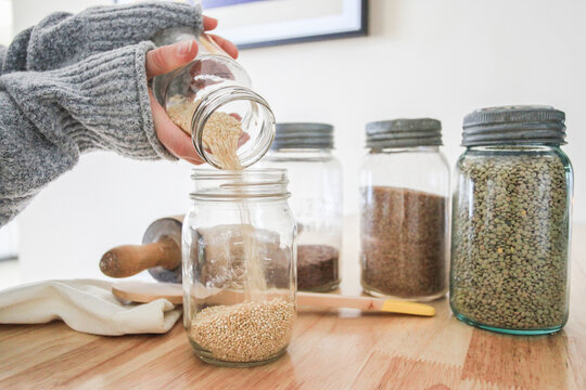 Woman pouring Quinoa into jar