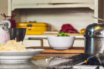 Close up of a bowl, full of onions, in a rustic kitchen.