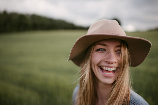 Laughing hipster woman in green field