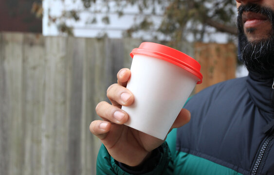 Young man drinking coffee outside