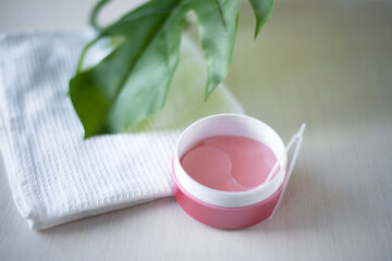 Pink hydrogel eye patches оn a light background. Bathroom treatments. Homemade face care.