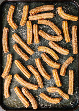 Cinnamon and sugar coated churros on baking sheet