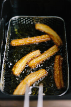Deep frying churros in hot sunflower oil