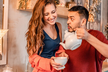 A young couple celebrates Christmas in a cozy country house concept of Winter holidays and Family holidays. Festive atmosphere.