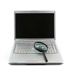 Laptop PC and magnifying glass indicating data security concept