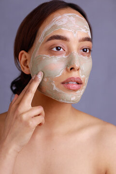woman applying facial mask