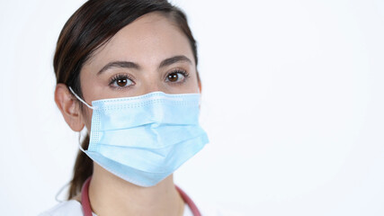 Young woman wearing face mask looking at camera on white back drop.