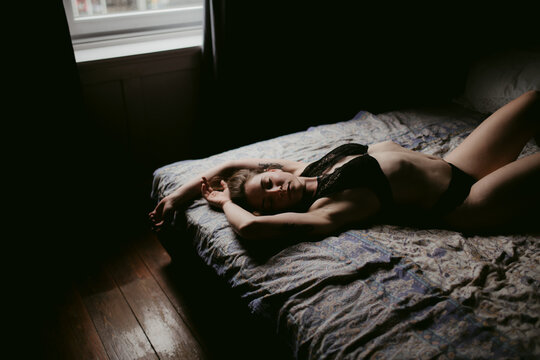 Sensual woman in underwear relaxing on bed