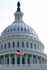 American flag in front of Capitol Hill in Washington DC with dome in daylight and facade details