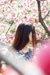Obraz na płótnie Canvas Spring girl with magnolia flowers. Face closed by hair. Conceptual photo.
