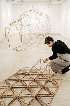 Artist Assembling A Large Abstract Sculpture In The Gallery