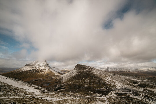 Snowy mountains against cloudy sky