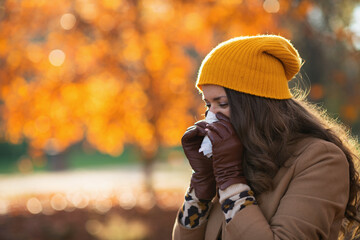 modern woman in beige coat and orange hat