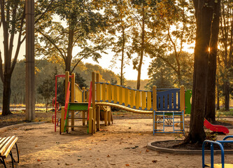 Fototapeta na wymiar Empty playground at sunrise in autumn scenery