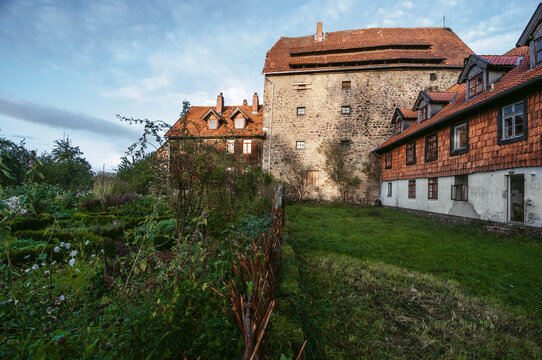 Old stone mansion with green meadow in garden