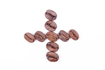 Naklejka premium Plus sign made of coffee beans on a white background. Coffee beans isolated on white. Macro.
