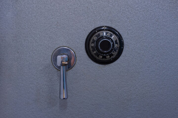 Close up of.the dial and handle of a metal safe