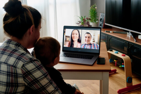 Young mother and toddler having fun with friends via internet
