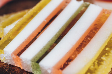 Slice of multicolored striped marmalade close-up. Colorful jelly candy close-up. Macro shot, selective focus.