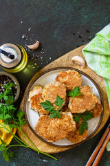 Healthy vegan food. Red fish cutlets on a dark stone or slate table. Top view flat lay background. Copy space.