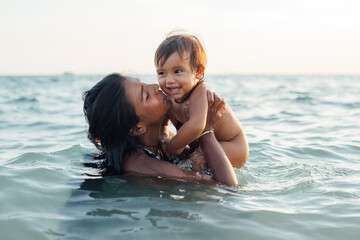 Mother playing with baby on beach