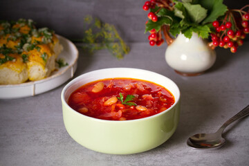 Beetroot soup made with vegetables beans and meat: borsht, bortsch, borshch, borscht. Garlic buns pampushky.