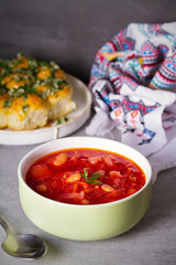 Beetroot soup made with vegetables beans and meat: borsht, bortsch, borshch, borscht. Garlic buns pampushky.