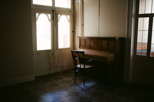 Living room of abandoned house with chair and piano