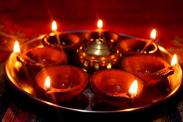 Traditional clay Diya lamps lit during Diwali celebration, Decoration of beautiful lamps of Indian aromatic earthenware in night, Selective Focus.
